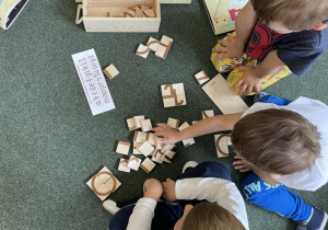 dzieci pracują z klockami do konstruowania liter